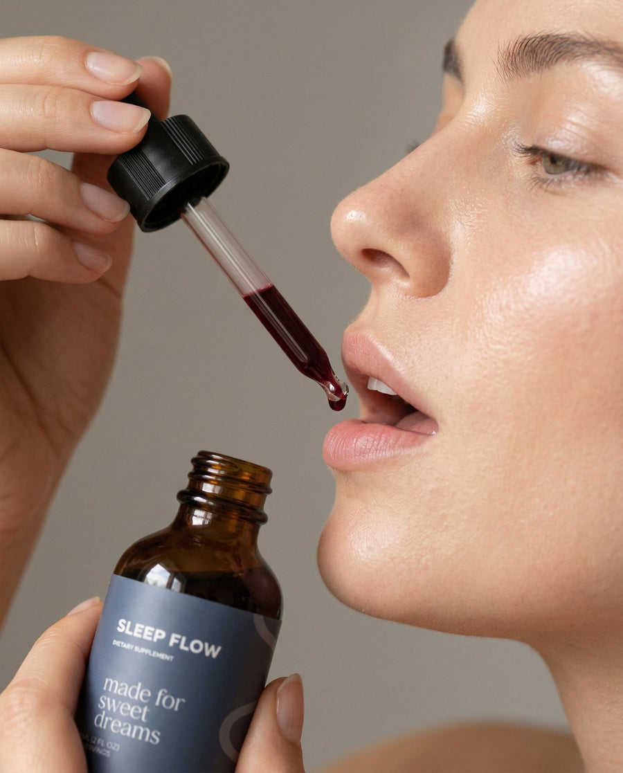 Close-up of a woman taking Flowever Sleep Flow drops from a dropper