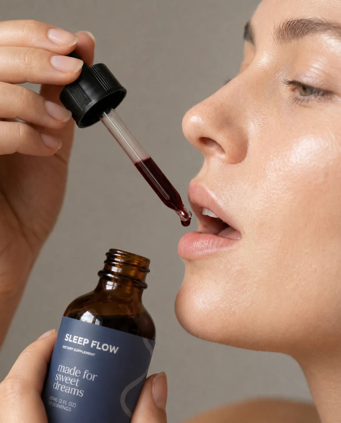 Woman taking Sleep Flow natural sleep supplement drops with a dropper